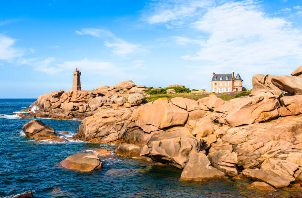 The Ploumanac'h lighthouse on the Pink Granite Coast in northern Brittany, France. Landscape on the Pink Granite Coast in northern Brittany on the municipality of Perros-Guirec, France, with the Ploumanac'h lighthouse, named Mean Ruz and made of the same pink granite. coastal feature stock pictures, royalty-free photos & images