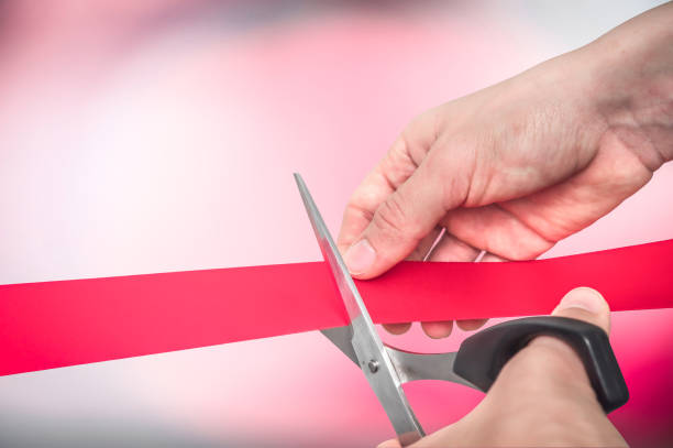 istock Hand with scissors cutting red ribbon - opening ceremony 1169106153