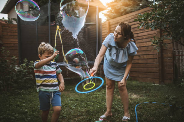 istock Little boy makes soap bubbles with her mum 1169106827