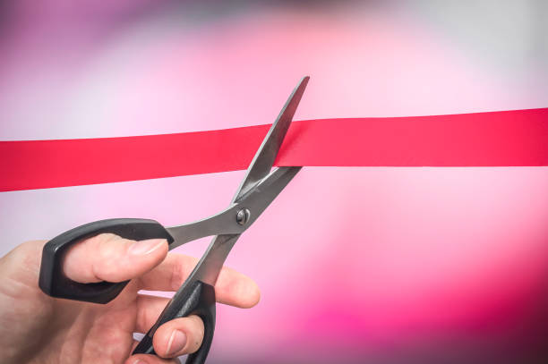 istock Hand with scissors cutting red ribbon - opening ceremony 1169106852