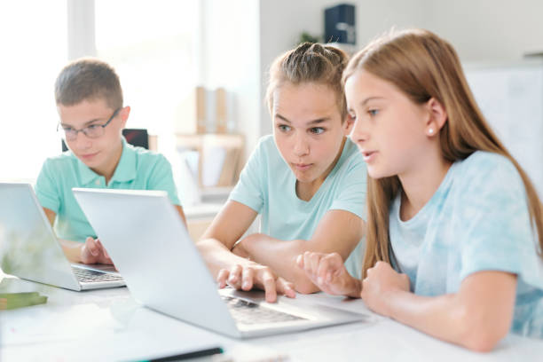 istock Middle school boy and girl looking at curious stuff on laptop display 1169111129