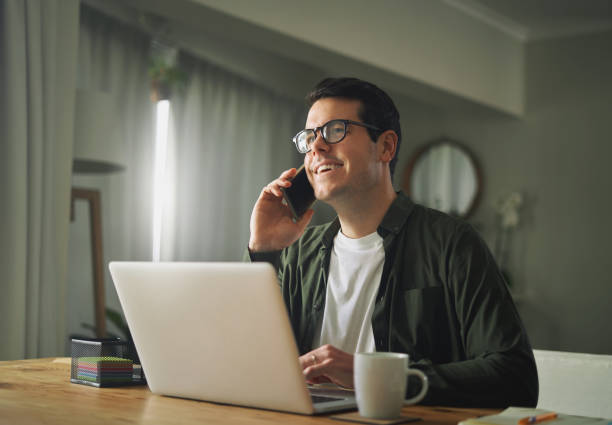 istock Man talking on a mobile phone and working on his laptop 1169114504