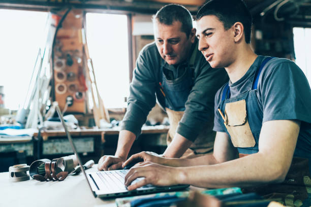 istock Carpenter and his assistant working on laptop 1169115858