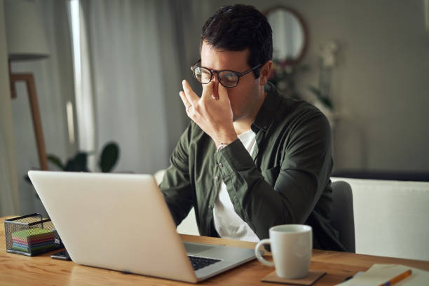 istock Man massaging nose feeling fatigue using laptop at home 1169116376