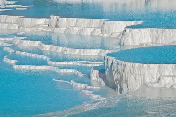 Pamukkale, meaning "cotton castle" in Turkish, is a natural site in Denizli in southwestern Turkey. The area is famous for a carbonate mineral left by the flowing water. It is located in Turkey's Inner Aegean region, in the River Menderes valley, which has a temperate climate for most of the year.