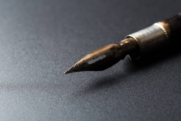 istock Old fountain pen on a black textured background 1169126266