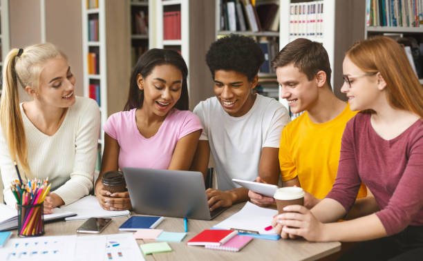 istock Group of young people working with laptop in library 1169126480