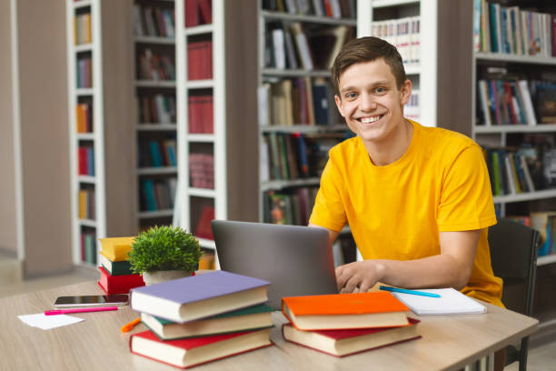 istock Happy intelligent student getting ready for exams in school library 1169127341