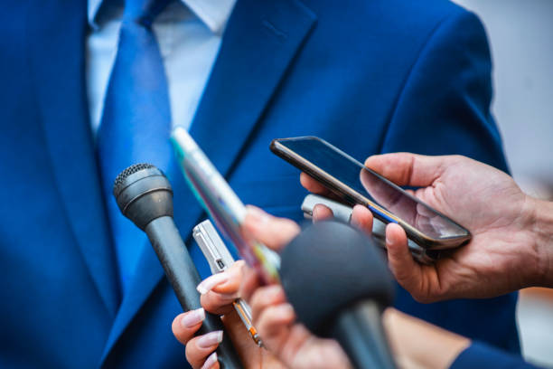 Media Interview. Journalists Interviewing Politician or Businessman Media Interview - journalists with microphones interviewing formal dressed politician or businessman. press room photos stock pictures, royalty-free photos & images