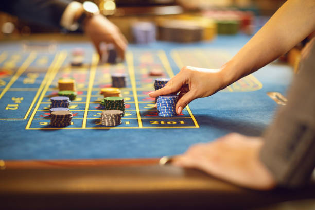 istock Hands with chips at poker roulette table gambling in a casino. 1169127619