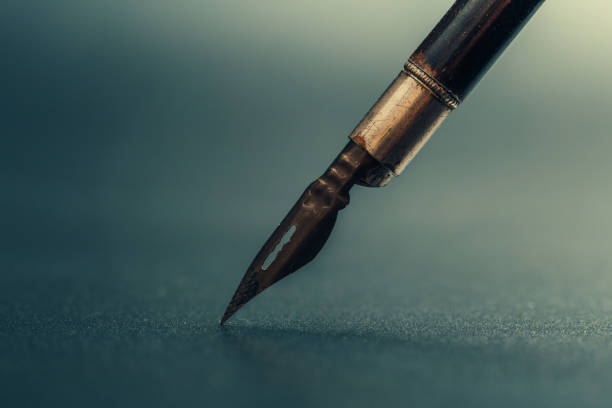 istock Old fountain pen on a black textured background 1169129384