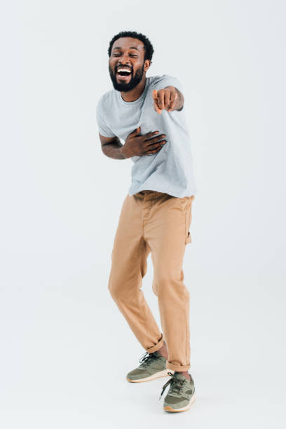 istock african american man laughing and pointing isolated on grey 1169130180