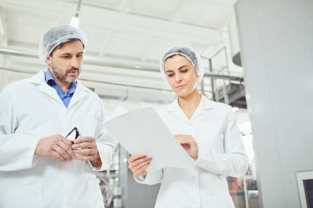 istock Two technologists in lab coats and masks at the factory. 1169130807