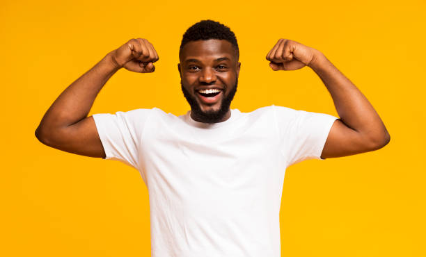 African american man smiling and showing biceps at camera