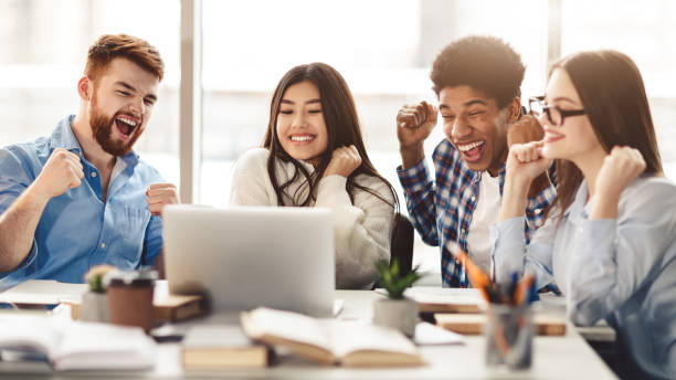 Surprised students getting exam results on laptop
