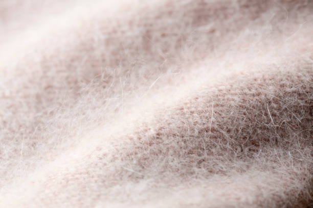 pink knitted angora and wool background. Background texture of pink pattern knitted fabric made of angora or wool. close up. wool stock pictures, royalty-free photos & images