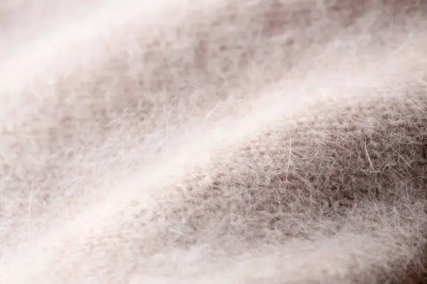 Background texture of pink pattern knitted fabric made of angora or wool. close up.