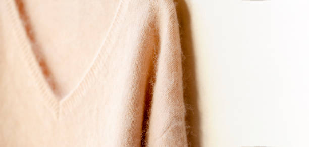 istock light pink sweater hanging on clothes hanger on white background. 1169134709