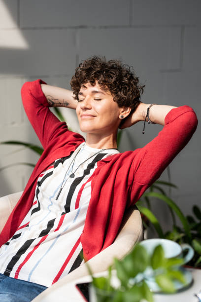 istock Happy young restful woman keeping her hands behind head while enjoying break 1169136342