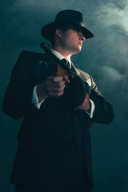 istock Retro gangster stands with machine gun in mist. 1169137481