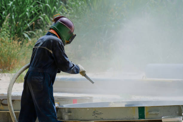 istock Worker is remove paint by air pressure sand blasting 1169143243