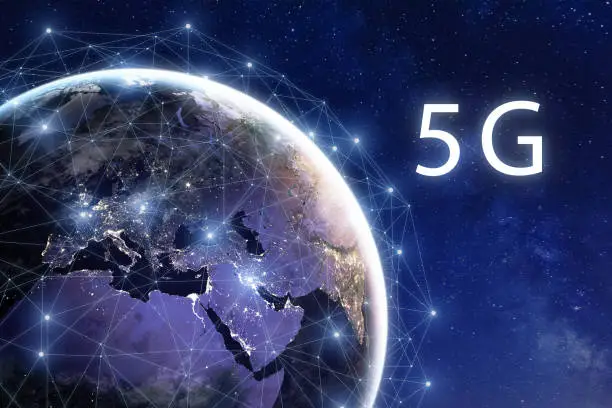 5G wireless mobile internet telecommunication network deployment in the world, high speed data communication technology, global connection around planet Earth with city lights viewed from space. Some elements from NASA (https://eoimages.gsfc.nasa.gov/images/imagerecords/57000/57752/land_shallow_topo_2048.jpg)