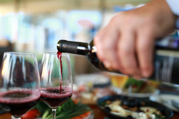 istock Person pouring red wine 1169145552