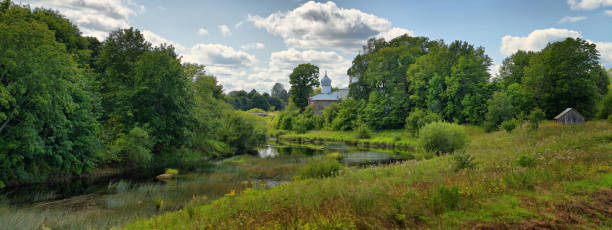 Panorama of the summer landscape with the Orthodox Church on the banks of a quiet, picturesque river