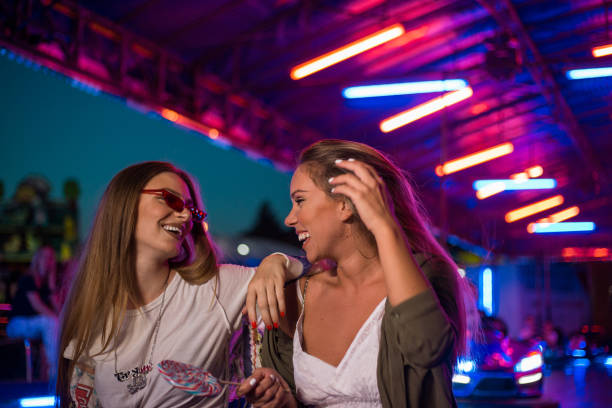 istock Two girlfriends having fun and laughing before going on a bumper car ride 1169148480