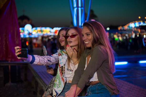istock Girlfriends taking selfies and eating candy at the fair 1169148804