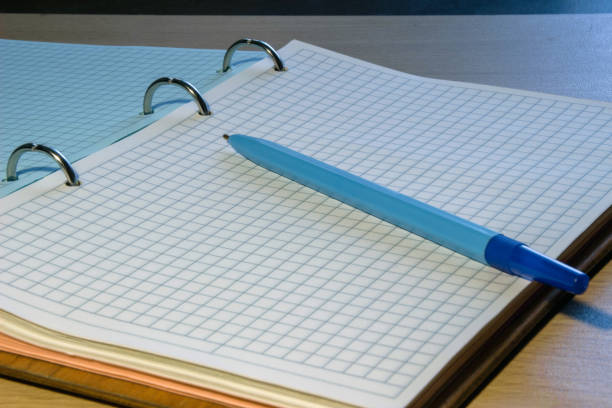 Blue pen is on a notebook in a cage. composition for writing instruments
