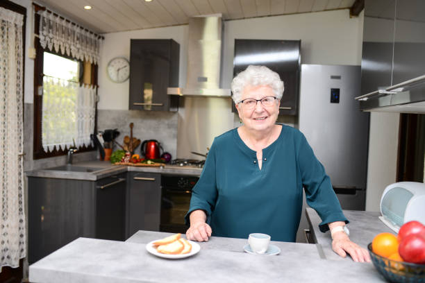 istock happy senior active woman drinking coffee in a modern kitchen at home 1169154125