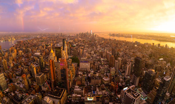 нью-йоркский горизонт с небоскребами манхэттена на драматическом бурном закате, сша. - manhattan aerial view new york city city стоковые фото и изображения