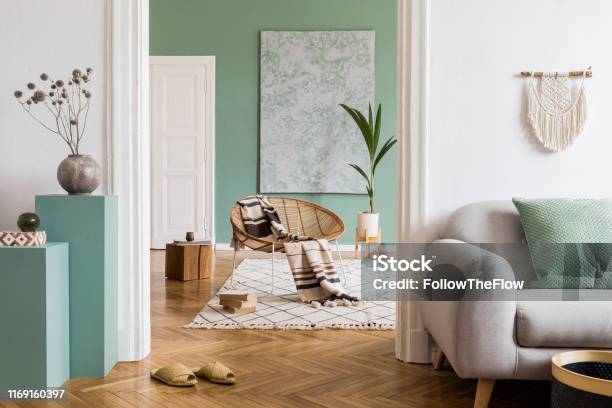 Modern And Bohemian Composition Of Interior Design At Apartment With Gray Sofa Rattan Armchair Wooden Cubes Plaid Tropical Plant Macrame And Elegant Accessories Stylish Home Decor Template Stock Photo - Download Image Now
