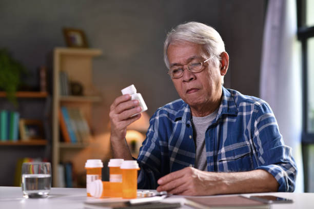 asiatischer senior mit seinen medikamentenflaschen - tablette fotos stock-fotos und bilder