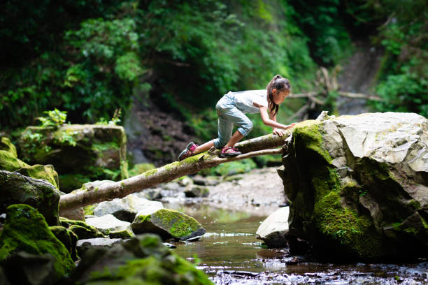 Girl crossing the log bridge