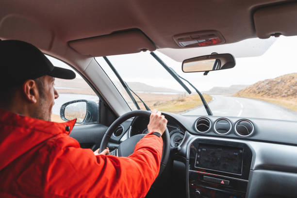 istock Man driving SUV car on coastline road 1169163166