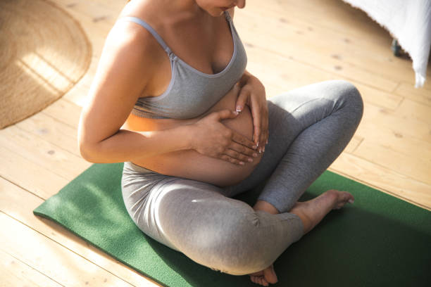 istock Charming pregnant lady holding hands on her belly 1169163394