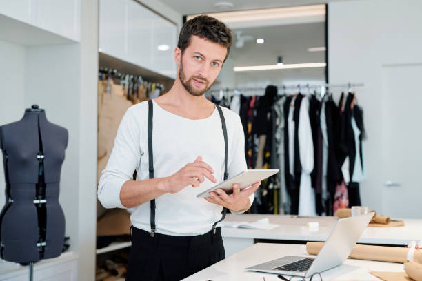 istock Young creative fashion designer with touchpad browsing in the net 1169167534