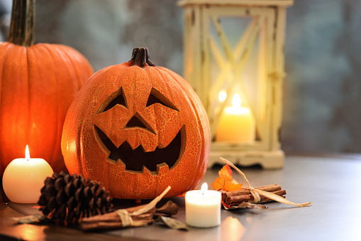 Halloween, autumn scene with pumpkins.  Group of objects includes: candles, pumpkins, jack o' lanterns, fall leaves, and pine cones.