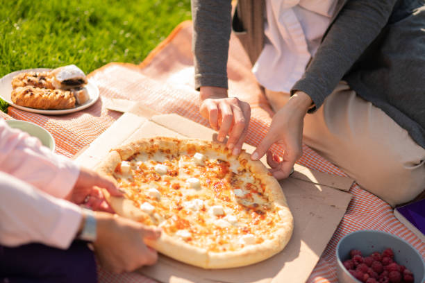 Close up of two students sharing cheese pizza