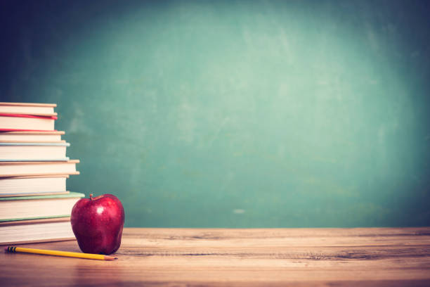 textbooks, red apple on wooden school desk with chalkboard, pencils. - blackboard back to school green picture frame imagens e fotografias de stock