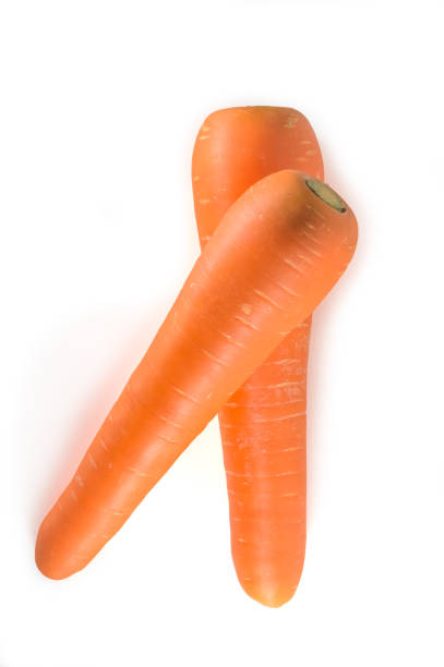 istock Two overlapping fresh orange carrots isolated on white background in strange appearance, vertical picture 1169174413