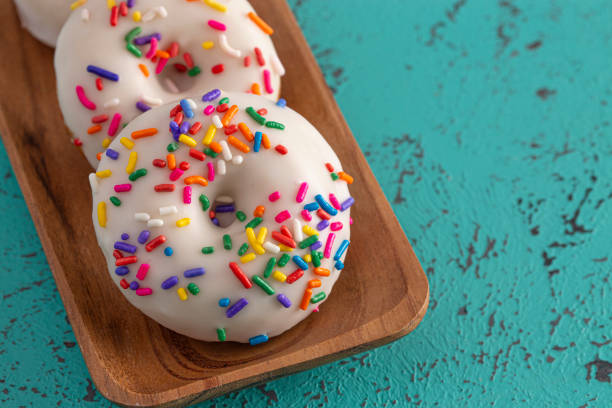 istock Cake Donut with White Frosting and Multicolored Sprinkles 1169174887