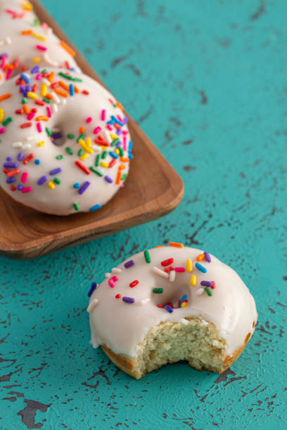 istock Cake Donut with White Frosting and Multicolored Sprinkles 1169174888