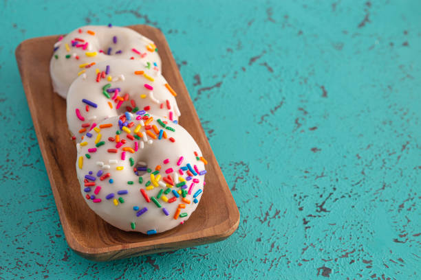 istock Cake Donut with White Frosting and Multicolored Sprinkles 1169174957