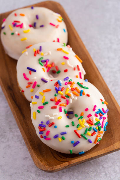 istock Cake Donut with White Frosting and Multicolored Sprinkles 1169175353