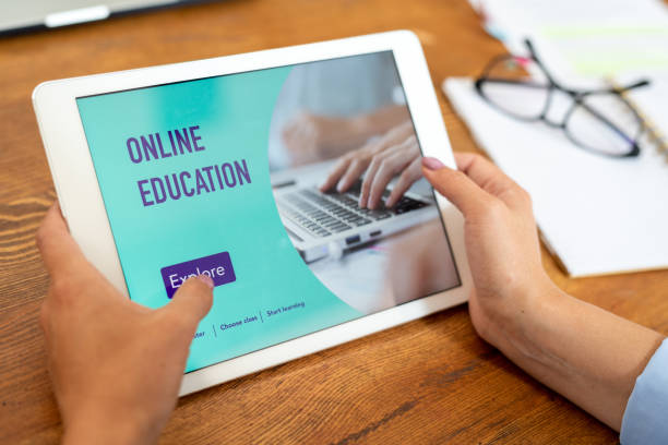 istock Female hands holding touchpad over wooden table while going to explore website 1169175884
