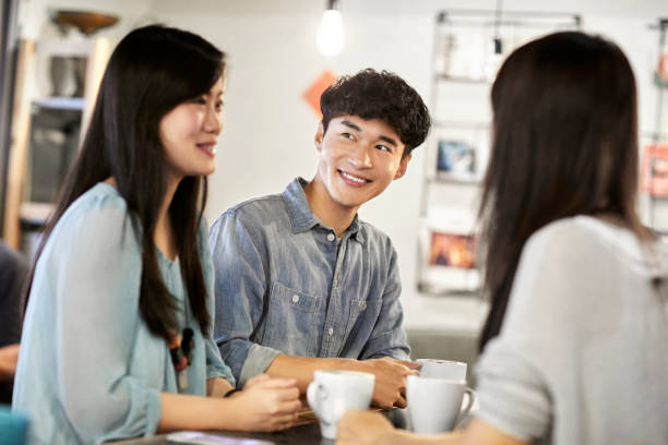 istock Smiling man having coffee with friends in cafe 1169177101