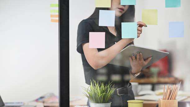 istock She likes to plan out her day in office with sticky note and tablet. 1169177620
